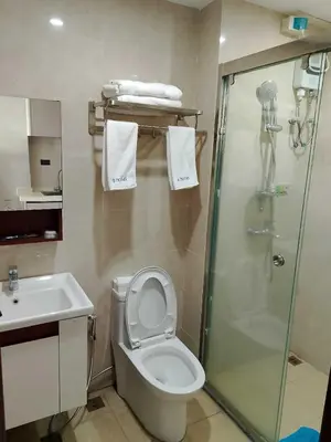 a bathroom with a shower and a toilet and a sink at Hotel S Casiana Residences in Manila