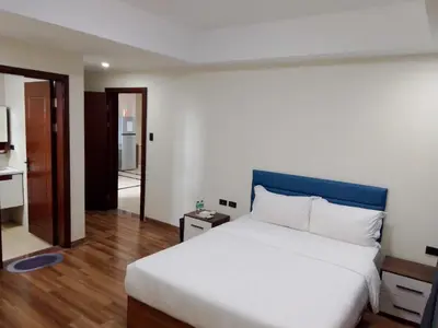 a bedroom with a large bed with a blue headboard at Hotel S Casiana Residences in Manila