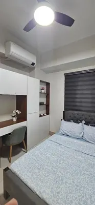 a bedroom with a bed and a desk and a ceiling fan at 2 Bedroom Mall of Asia and Airport in Manila