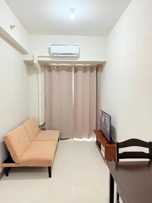 a living room with a couch and a tv at Comfortable Cozy Staycation in Manila