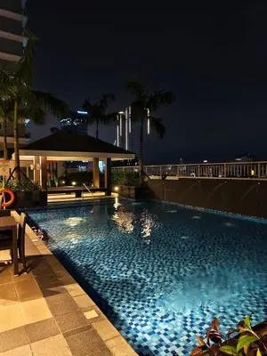 a large swimming pool at night on a building at Comfortable Cozy Staycation in Manila
