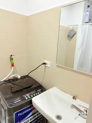 a bathroom with a sink and a mirror at Comfortable Cozy Staycation in Manila