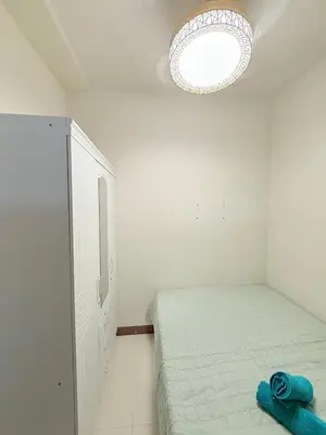 a white bedroom with a bed and a light at Comfortable Cozy Staycation in Manila