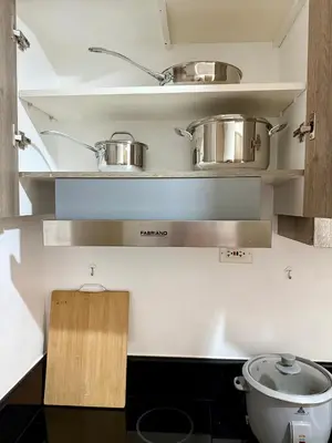 a kitchen with two pots and pans on shelves at Nestled Haven in Manila