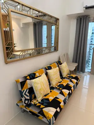 a couch in a living room with a mirror at Nestled Haven in Manila