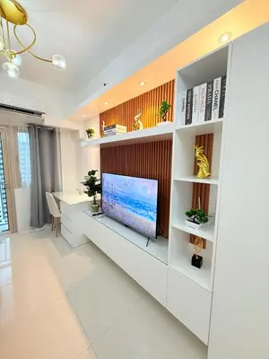 a living room with a tv on a wall at Nestled Haven in Manila