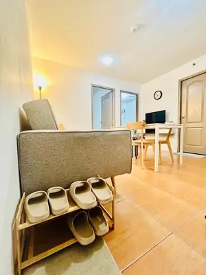 a living room with a couch and some shoes at 2BR Relaxing Oasis with pool access Sorrento Oasis in Manila