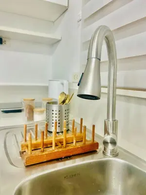 a kitchen sink with a tray of utensils and a faucet at 2BR Relaxing Oasis with pool access Sorrento Oasis in Manila