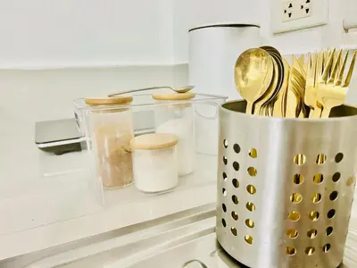 a container of utensils sitting on a kitchen counter at 2BR Relaxing Oasis with pool access Sorrento Oasis in Manila