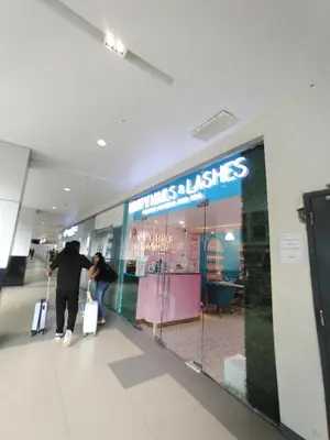 two people walking through a store window with luggage at 2 Bedrooms 1CR Shore 1 Residences upto 7 person-15mins walk to MOA in Manila