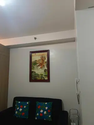 a living room with a couch and a picture on the wall at SHORE 2 Residences by ASKrentals in Manila