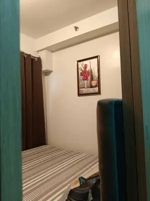 a small room with a bed and a mirror at SHORE 2 Residences by ASKrentals in Manila