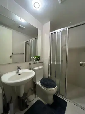 a bathroom with a toilet and a sink and a shower at R&D comfy staycation in Manila