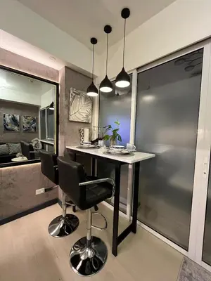 a kitchen with a table and two black chairs at R&D comfy staycation in Manila