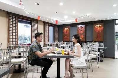 a man and woman sitting at a table in a restaurant at Jinjiang Inn - Ortigas in Manila