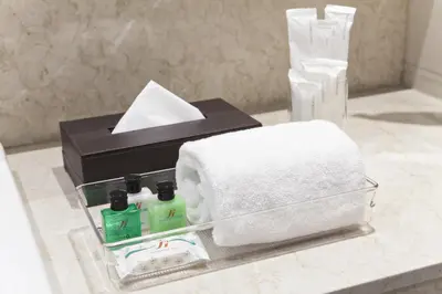 a bathroom counter with towels and a box of tissues at Jinjiang Inn - Ortigas in Manila