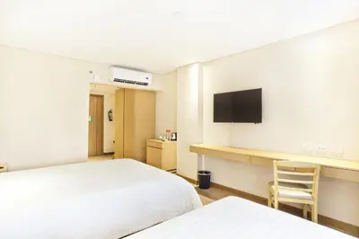 a hotel room with two beds and a television at Jinjiang Inn - Ortigas in Manila