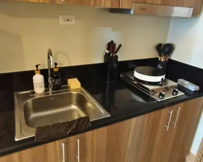 a kitchen counter with a sink and a stove at Las Vegas of the Philippines in Pasay Manila Luxury Near NAIA Airport x Solaire x Okada x City of Dreams and Casinos Enjoy FREE Pool Access n HighSpeed WIFI and Netflix Comfort with ResortType Living Secure Your Limited Offer This Month in Manila