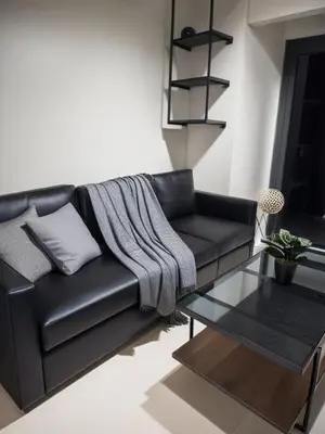 a black leather couch in a living room with a table at Spacious Homes at Shore Residence Near Mall of Asia in Manila