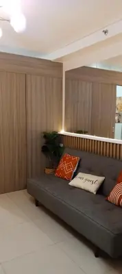 a couch with pillows on it in a room at Spacious Homes at Shore Residence Near Mall of Asia in Manila