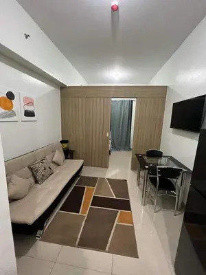 a living room with a couch and a table at Spacious Homes at Shore Residence Near Mall of Asia in Manila