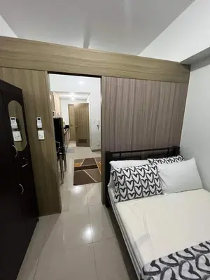 a bedroom with a bed with a wooden headboard at Spacious Homes at Shore Residence Near Mall of Asia in Manila