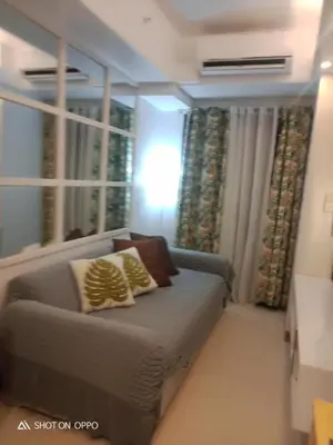 a small bedroom with a couch and a window at Spacious Homes at Shore Residence Near Mall of Asia in Manila