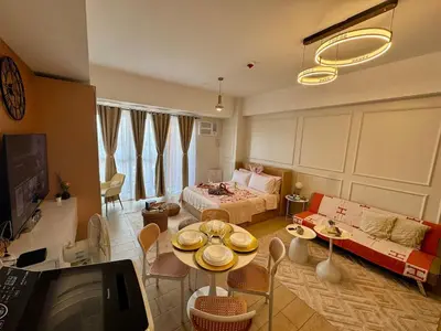 a living room with a couch and a table with chairs at Spacious Staycation with venice grand canal view in Manila