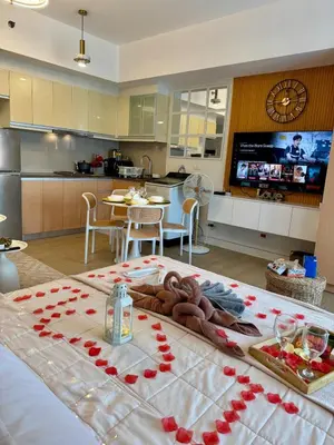 a room with a large bed with red roses on it at Spacious Staycation with venice grand canal view in Manila