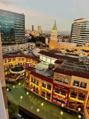 a view of a city with buildings and a clock tower at Spacious Staycation with venice grand canal view in Manila
