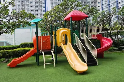a playground with different colored slides on the grass at Boho City View 1br Apt in Makati with Netflix in Manila