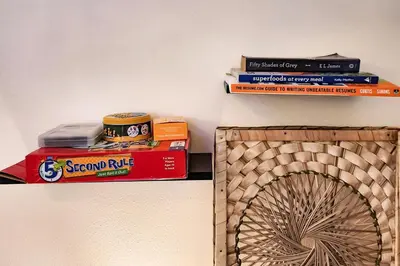 a stack of books and a fan on a shelf at Boho City View 1br Apt in Makati with Netflix in Manila