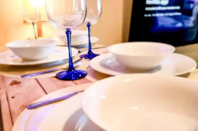 a table with two wine glasses and bowls on it at Boho City View 1br Apt in Makati with Netflix in Manila