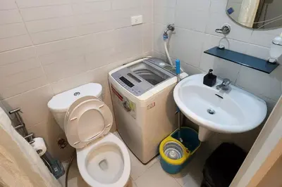 a small bathroom with a toilet and a sink at Cozy Pool & City View 1br Apt in Makat with Netflix in Manila