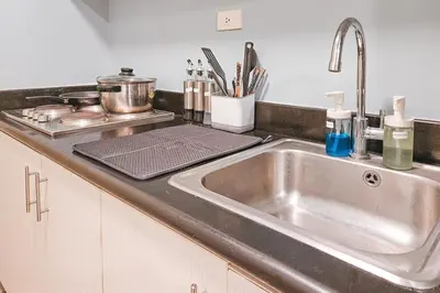 a kitchen counter with a sink and a stove at Luxury 2br in Makati with Billiard & Netflix in Manila