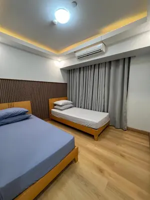 a bedroom with two beds and a window at Acqua Escape in Manila