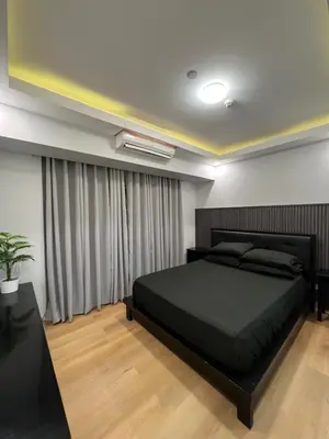 a bedroom with a large black bed and curtains at Acqua Escape in Manila