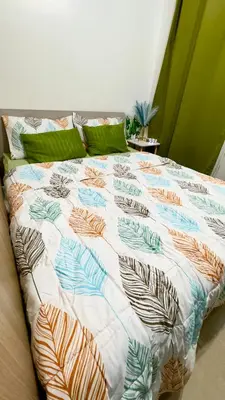 a bed with a quilt on it in a room at Divine Staycation in Manila