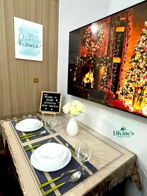 a table with plates and glasses and a fireplace at Divine Staycation in Manila