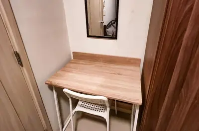 a wooden table with a white chair and a mirror at Gaming 2br in Makati with City View Arcade Netflix in Manila