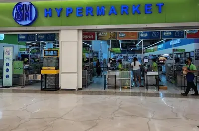 a supermarket with people standing outside of a store at Gaming 2br in Makati with City View Arcade Netflix in Manila