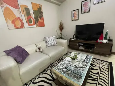 a living room with a couch and a flat screen tv at 52sqmComfy2BR and 2BA Resort-inspired Flair Towers Condo in Manila