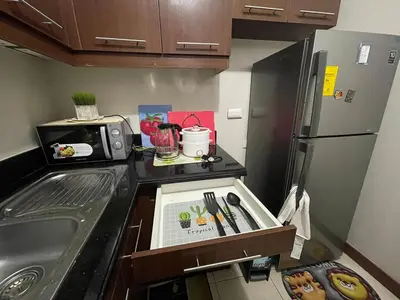a small kitchen with a sink and a refrigerator at 52sqmComfy2BR and 2BA Resort-inspired Flair Towers Condo in Manila