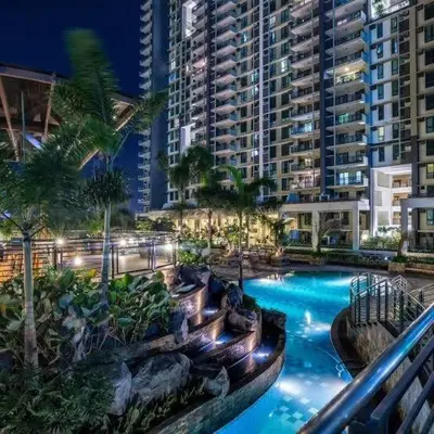 a large swimming pool with palm trees and buildings at 52sqmComfy2BR and 2BA Resort-inspired Flair Towers Condo in Manila