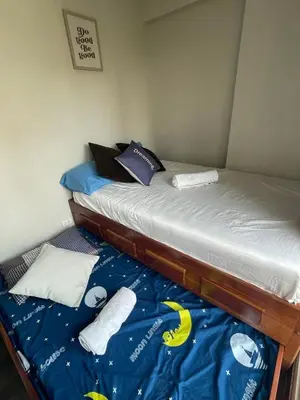 a bedroom with two twin beds with blue sheets at 52sqmComfy2BR and 2BA Resort-inspired Flair Towers Condo in Manila