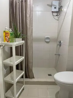 a bathroom with a white toilet and a shower at 52sqmComfy2BR and 2BA Resort-inspired Flair Towers Condo in Manila