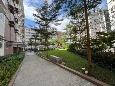 a walkway through a park with trees and buildings at Aras Solace Place in Trece Martires