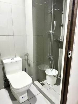 a bathroom with a toilet and a shower at City Scape Comforts Makati in Manila