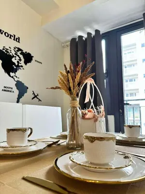 a table with plates and cups and a world map on the wall at CASA BELLA - Shore 3 MOA, Pasay in Manila