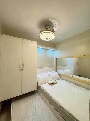 a bedroom with a large bed with a cabinet at CASA BELLA - Shore 3 MOA, Pasay in Manila